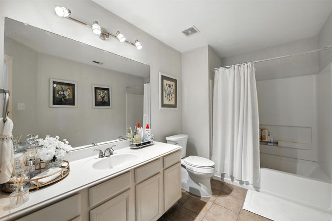 Full bath featuring tile patterned floors, vanity, and shower / tub combo with curtain | Image 20