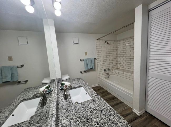 Full bath with baseboards, wood finished floors, vanity, and shower combination | Image 11