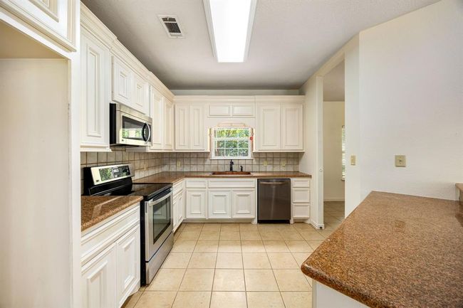 There is an abundance of storage space above and below the countertop and even the refrigerator. | Image 13