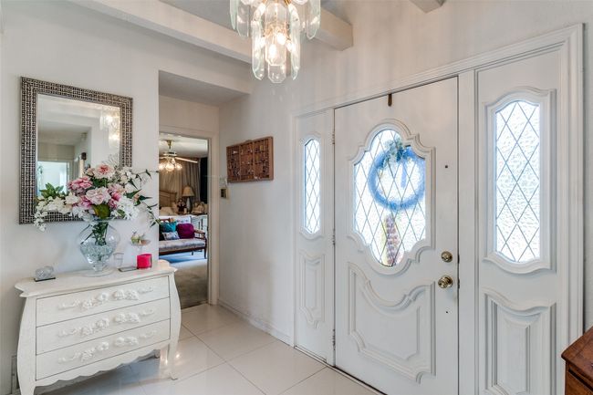 Entryway with a chandelier, healthy amount of natural light, light tile patterned floors, and ceiling fan | Image 4