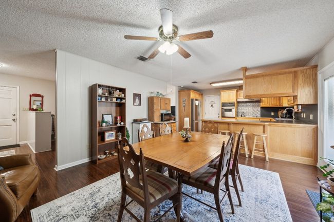 Dining room with visible vents, ceiling fan, a textured ceiling, and dark wood finished floors | Image 12