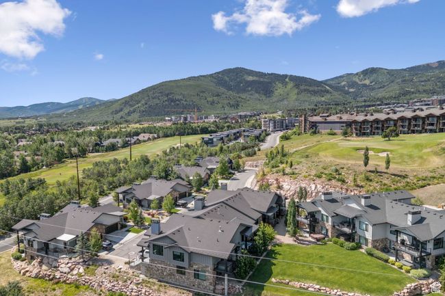 Aerial perspective of suburban area with a mountain backdrop and a golf club | Image 41