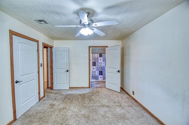 Unfurnished bedroom with carpet, a textured ceiling, baseboards, and a ceiling fan | Image 10