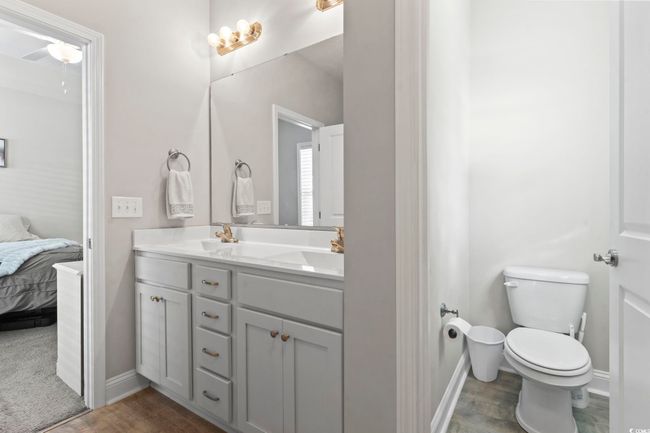 Bathroom with double vanity, wood finished floors, baseboards, toilet, and connected bathroom | Image 23