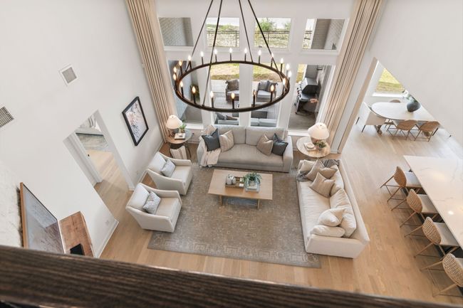 Sunken living room with a high ceiling, wood finished floors, and a chandelier | Image 30
