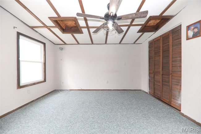 Unfurnished bedroom with baseboards, vaulted ceiling, a closet, and carpet | Image 17