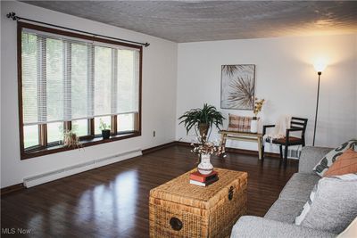 Living room featuring dark wood-type flooring and baseboard heating | Image 3