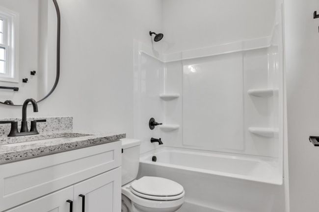 Private bath for 2nd guest bedroom with 10 ft ceilings, granite & modern decor and fixtures all highlighted by a window for natural lighting. | Image 25