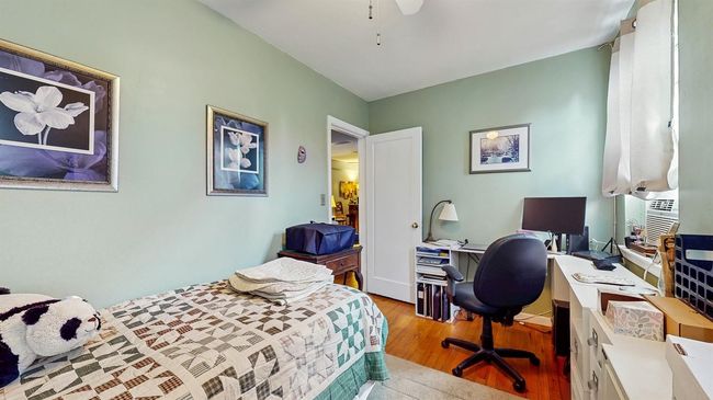 Bedroom with an office area, wood finished floors, cooling unit, and ceiling fan | Image 15