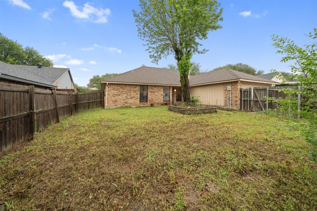 Rear view of property featuring a yard, brick siding, a fenced backyard, and roof with shingles | Image 23