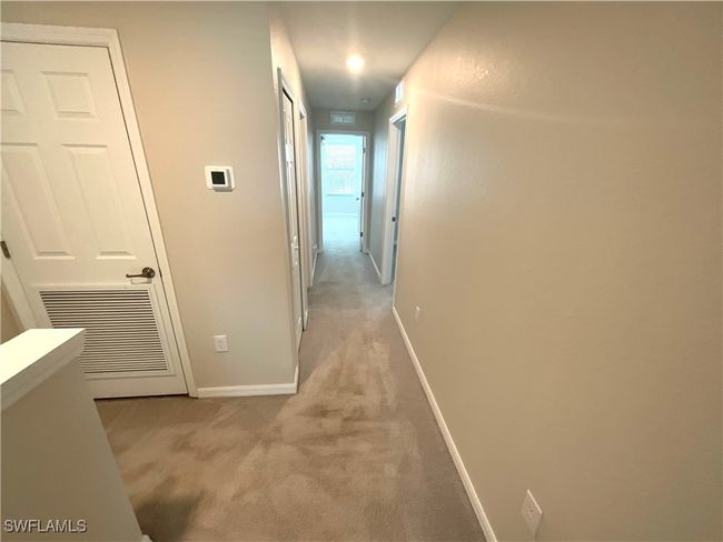 Hallway with light carpet and baseboards | Image 14