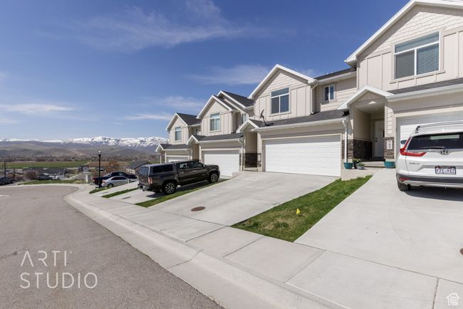 View of front facade with a mountain view, stone siding, a garage, board and batten siding, and driveway | Image 4