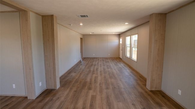 Unfurnished room with wood finished floors, a decorative wall, and recessed lighting | Image 35
