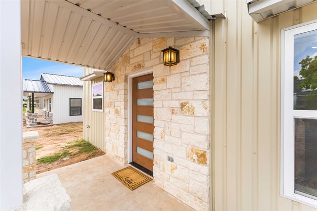 Doorway to property with stone siding and board and batten siding | Image 6