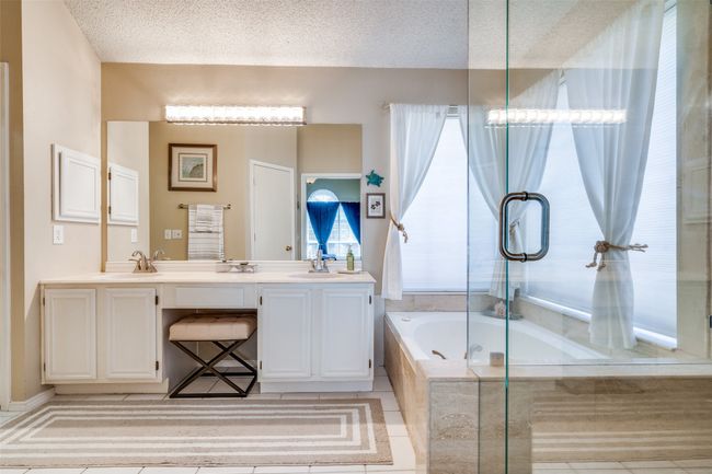 Dual sinks flanking the vanity space, updated lighting, a private water closet and a neutral color scheme round out the primary bath. | Image 19