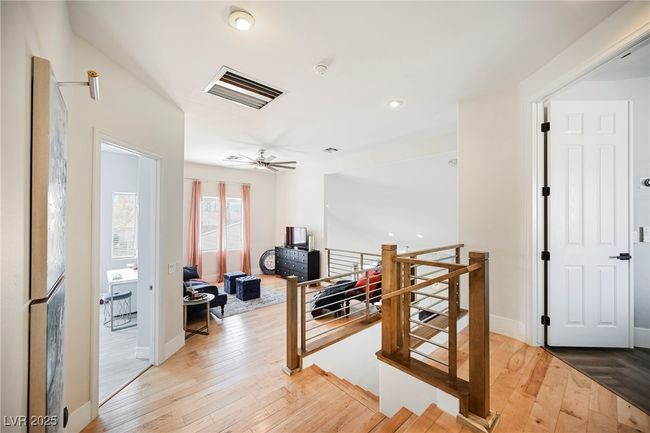 Corridor featuring light wood-style flooring, visible vents, baseboards, and an upstairs landing | Image 41