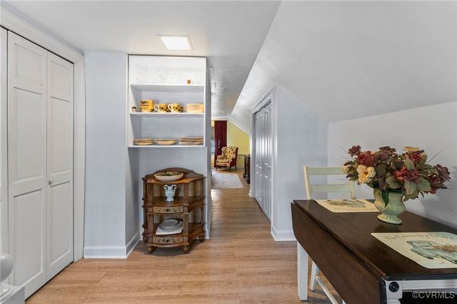 Hallway featuring light wood-type flooring, lofted ceiling, and baseboards | Image 17