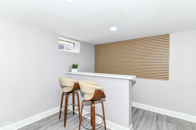 bar featuring light wood-style flooring, baseboards, and recessed lighting | Image 25