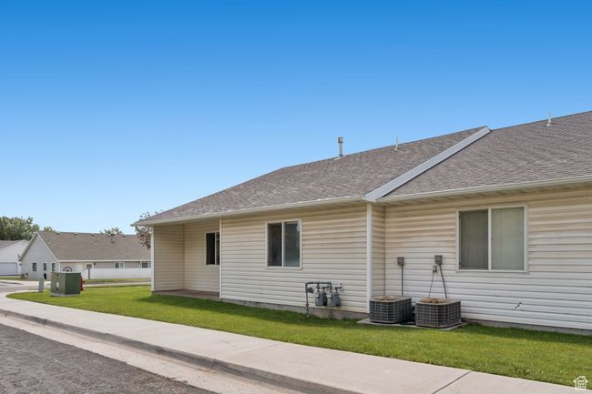 View of home's exterior with a shingled roof and a lawn | Image 21