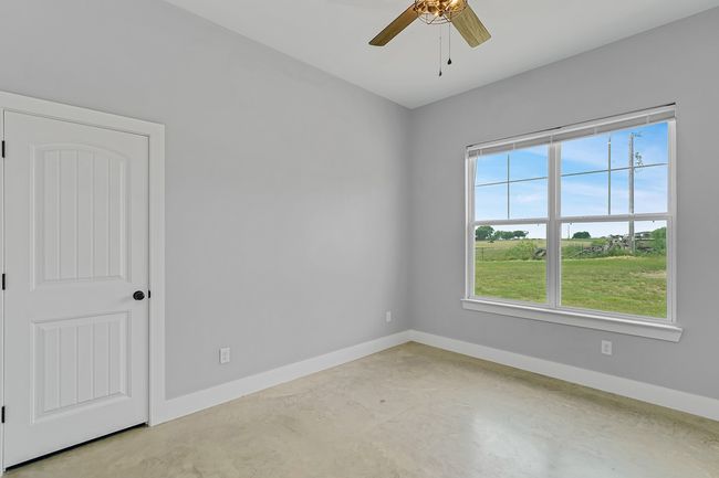 Unfurnished room with concrete floors, ceiling fan, and baseboards | Image 13
