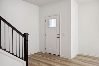 An open entry space characterized with wrought iron spindles and stairs. | Image 3