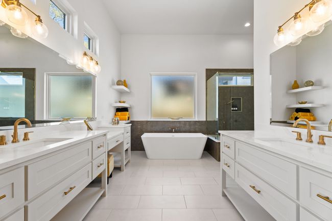 Bathroom with two vanities, a sink, a stall shower, and tile walls | Image 18