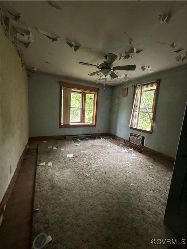 Empty room featuring a wall mounted air conditioner, ceiling fan, baseboards, and a healthy amount of sunlight | Image 19