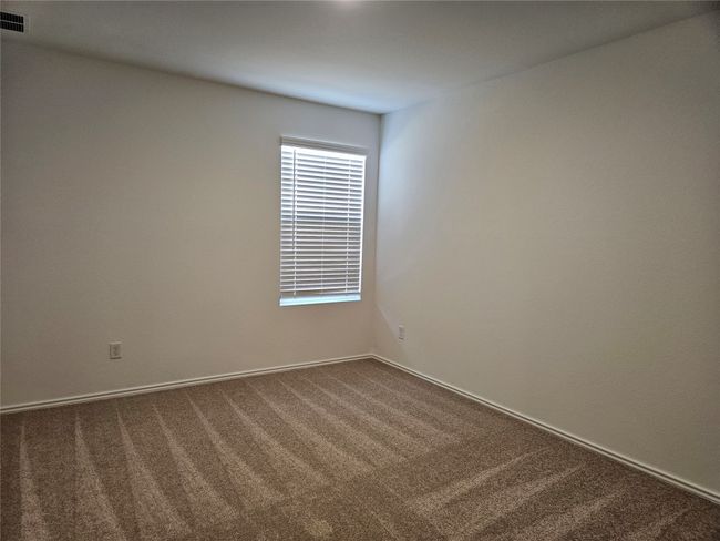 Empty room featuring visible vents and dark carpet | Image 7