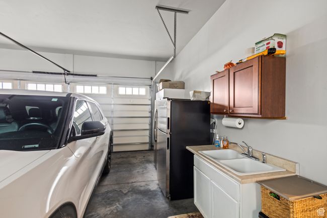Garage featuring stainless steel refrigerator and sink | Image 82