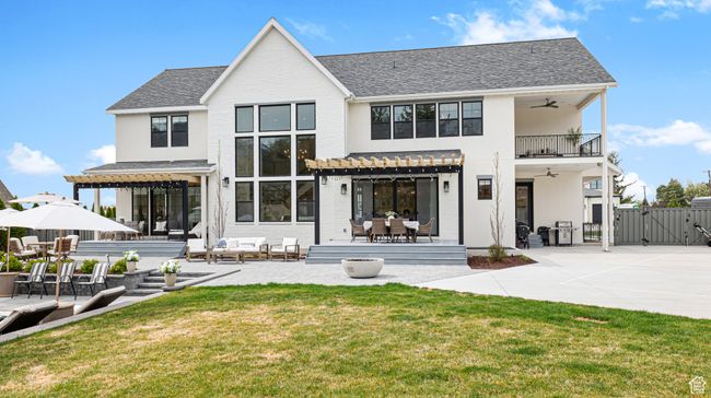 Rear view of house with a gate, a pergola, outdoor lounge area, a yard, and ceiling fan | Image 51