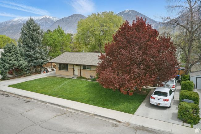 View of front of property with brick siding, driveway, a front yard, and a mountain view | Image 34