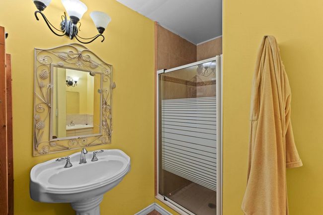Bathroom with a sink, a notable chandelier, and a stall shower | Image 14