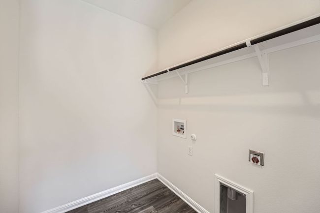 Washroom featuring baseboards, laundry area, washer hookup, dark wood-type flooring, and hookup for a gas dryer | Image 24