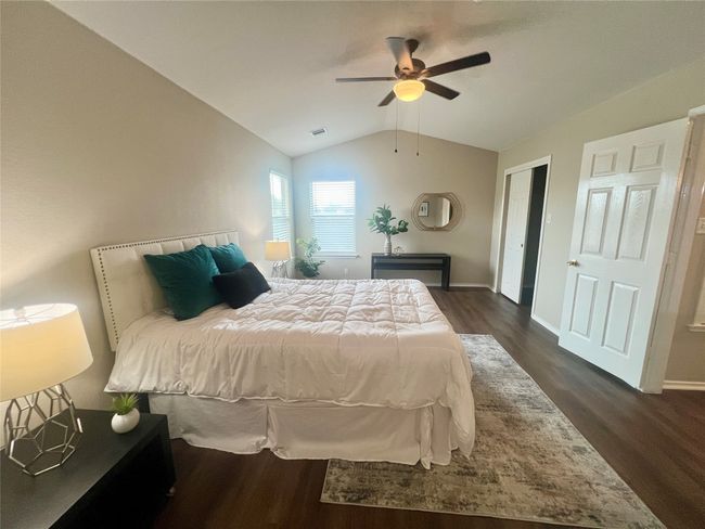 Bedroom with dark wood-type flooring, lofted ceiling, baseboards, and a ceiling fan | Image 19