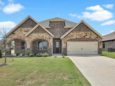 Mediterranean / spanish home featuring a front lawn, central AC, and a garage | Image 1