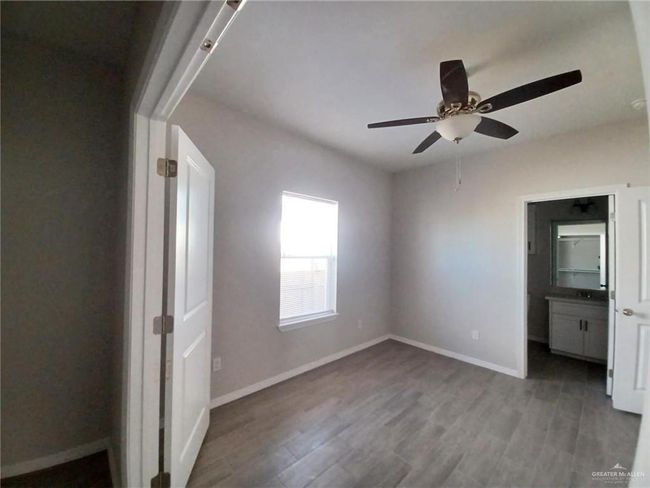 Unfurnished bedroom featuring wood finished floors, baseboards, and ceiling fan | Image 4