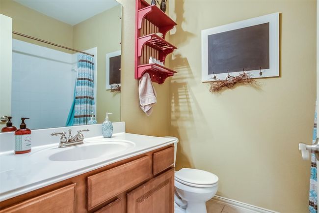 Downstairs full bath with a tub - shower combo & tile floors is right outside of the secondary bedroom. | Image 7