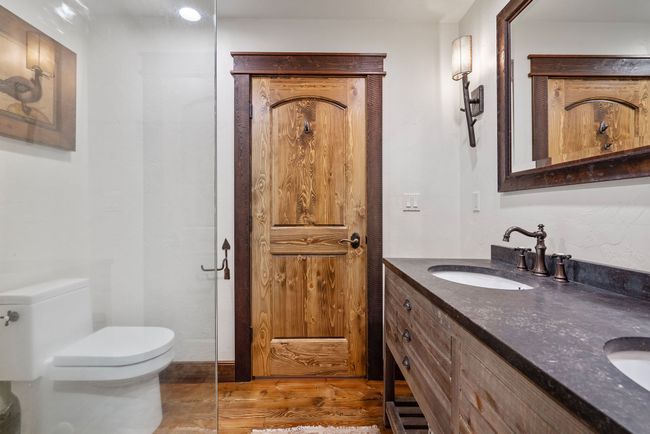 Full bathroom featuring double vanity, toilet, a shower, a sink, and wood finished floors | Image 47