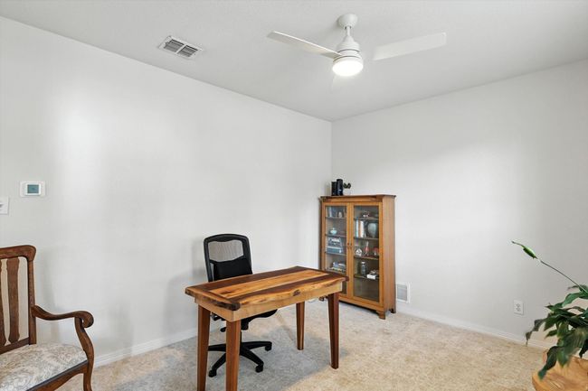 Office area featuring light colored carpet and a ceiling fan | Image 8