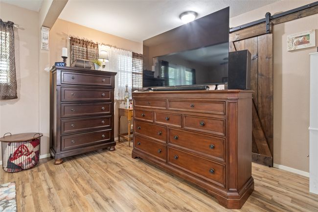 Bedroom featuring light wood finished floors and a barn door | Image 11