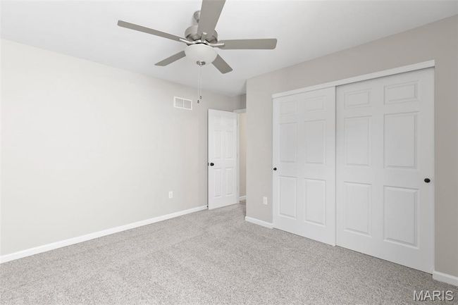 Unfurnished bedroom with carpet flooring, baseboards, a closet, and ceiling fan | Image 6