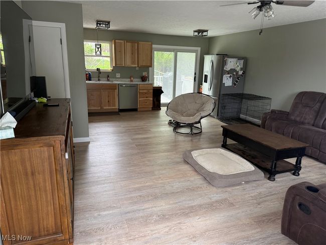 Living area with light wood-style flooring and ceiling fan | Image 9