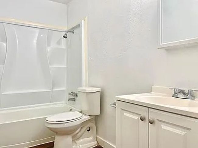 Full bath featuring vanity, shower / bath combination, and wood finished floors | Image 6
