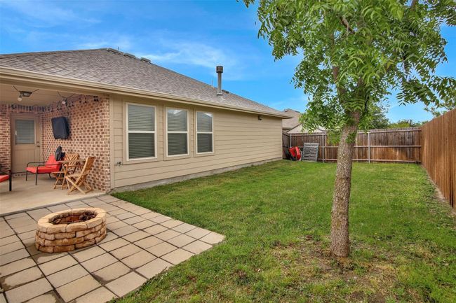 View of yard with a patio area and an outdoor fire pit | Image 26