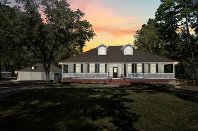 A warm evening sunset casts a golden glow over this cozy home. | Image 3