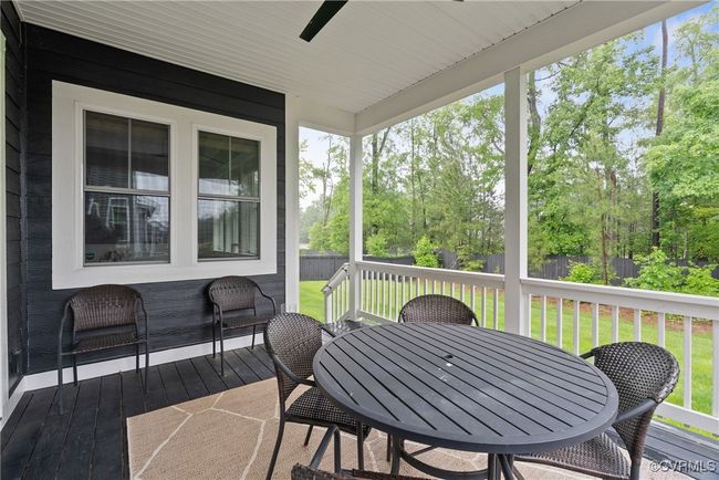 Deck with a ceiling fan, outdoor dining space, and view of wooded area | Image 48