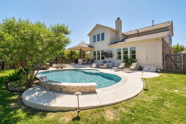 View of swimming pool with a patio area, a fenced backyard, a fenced in pool, and a yard | Image 33
