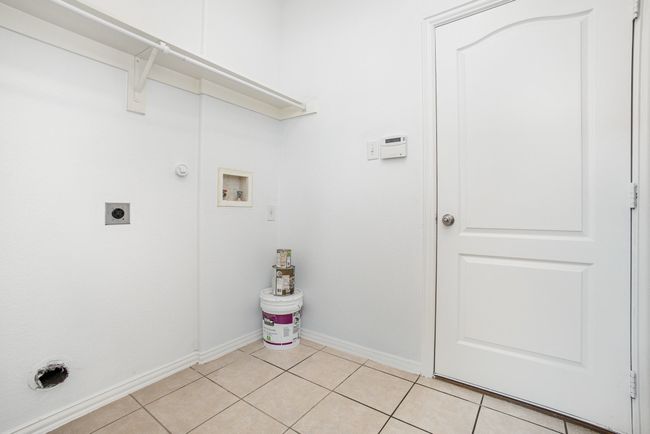 Laundry room with hookup for a washing machine, laundry area, electric dryer hookup, and light tile patterned floors | Image 16