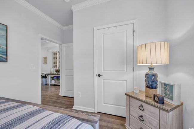 Bedroom featuring dark wood-type flooring, crown molding, and baseboards | Image 8