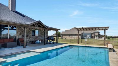 View of swimming pool with an outdoor living space, a pergola, a lawn, and a patio area | Image 2